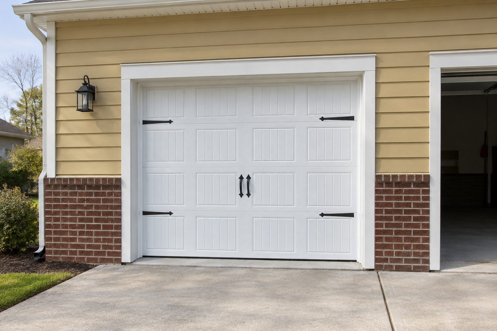 Closed white carriage-style single-car garage door, the safest position for a door with a broken spring