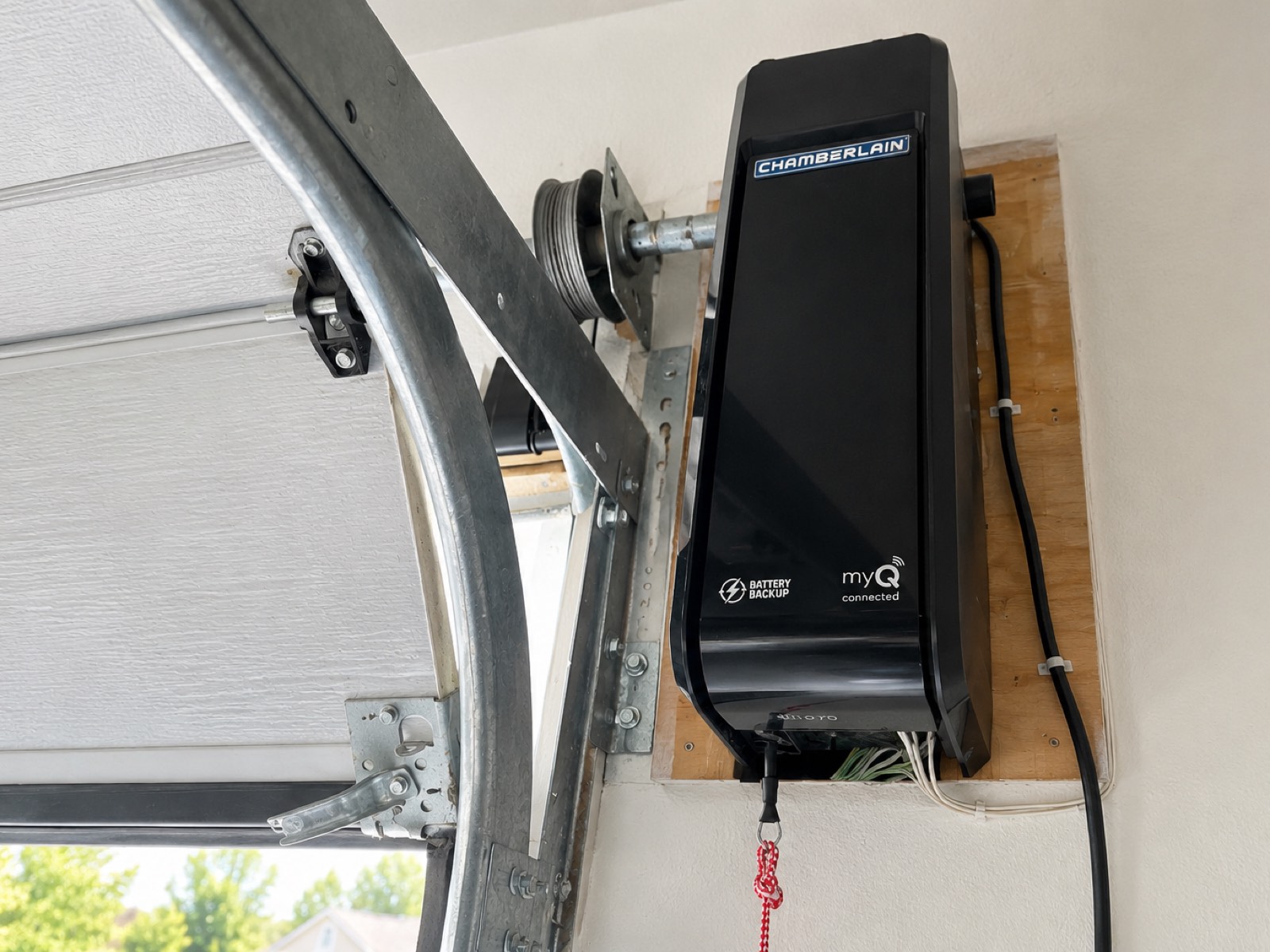 Wall-mount garage door opener installed on the torsion bar beside a door