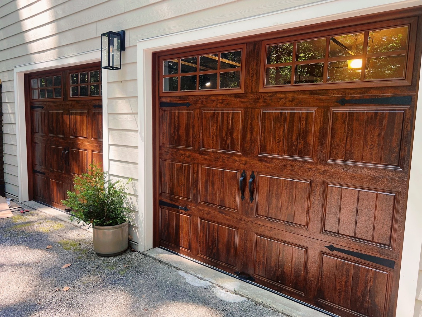 Two new wood-tone carriage-style garage doors with windows